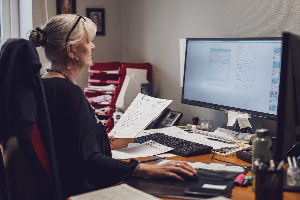 Kvinna jobbar med administration på sin dator